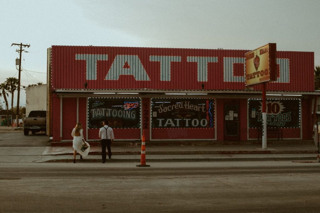 bride and groom in front of tattoo shop in las vegas